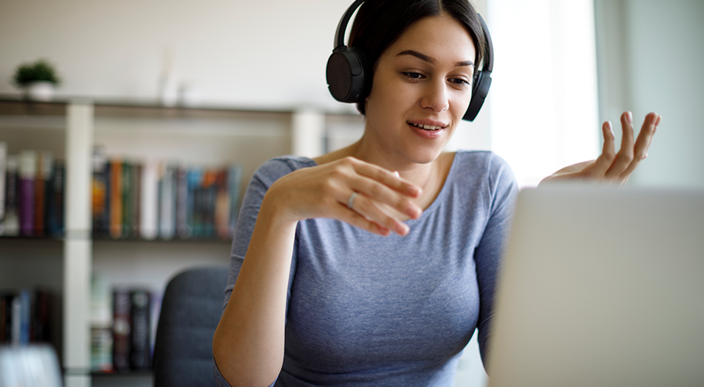 Young woman having video call on laptop computer at home